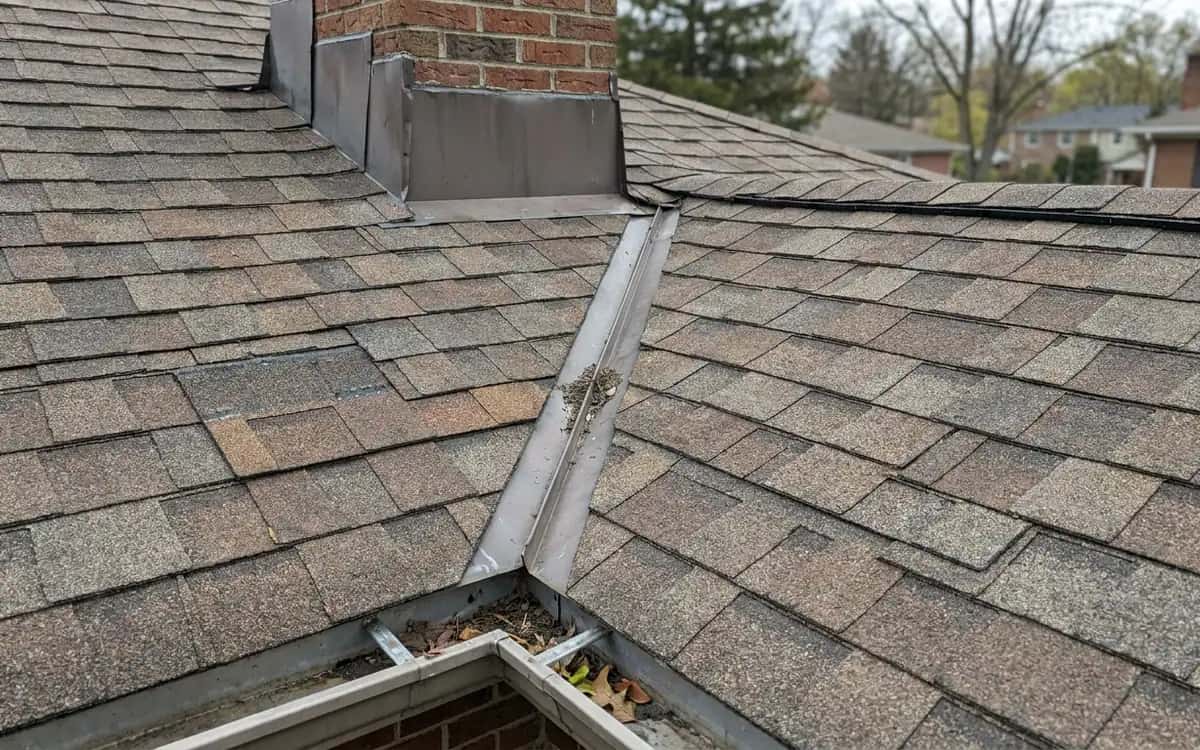 Roof valley, chimney flashing, and gutter on a residential roof