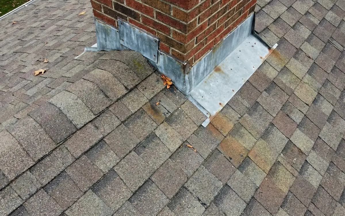 Close aerial view of roof flashing and shingles