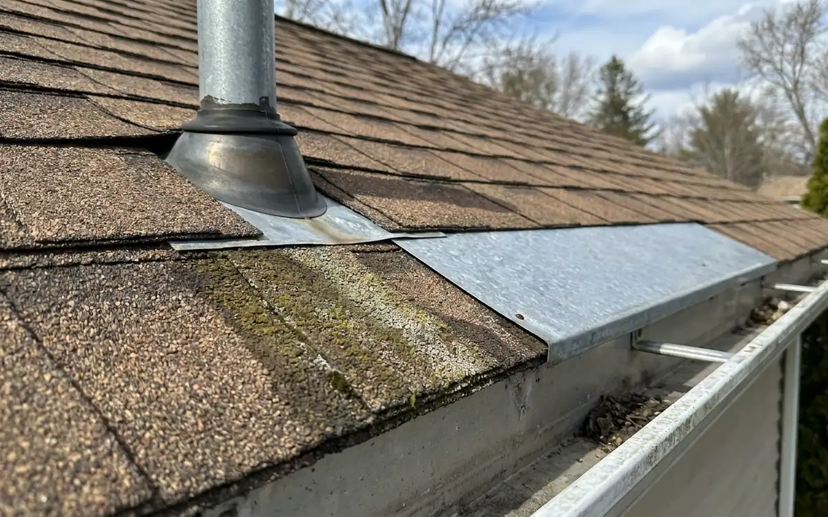 Vent boot, roof flashing, shingles, and gutter edge