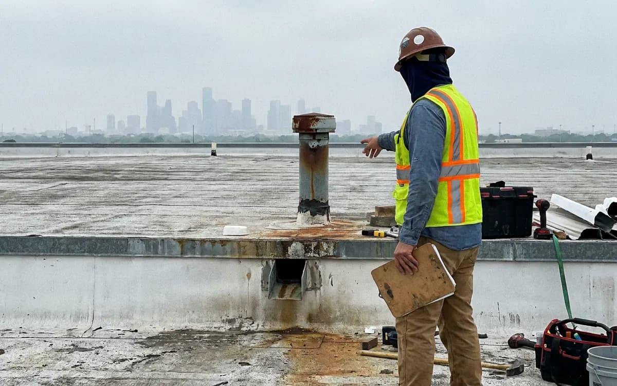 Inspector reviewing details on a low-slope commercial roof