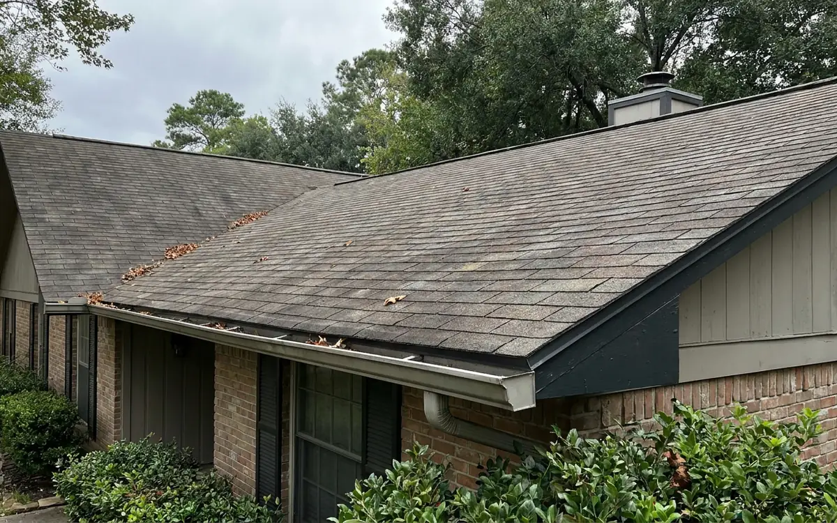 Wide view of a rental property roof, gutters, and intact shingles at lease start