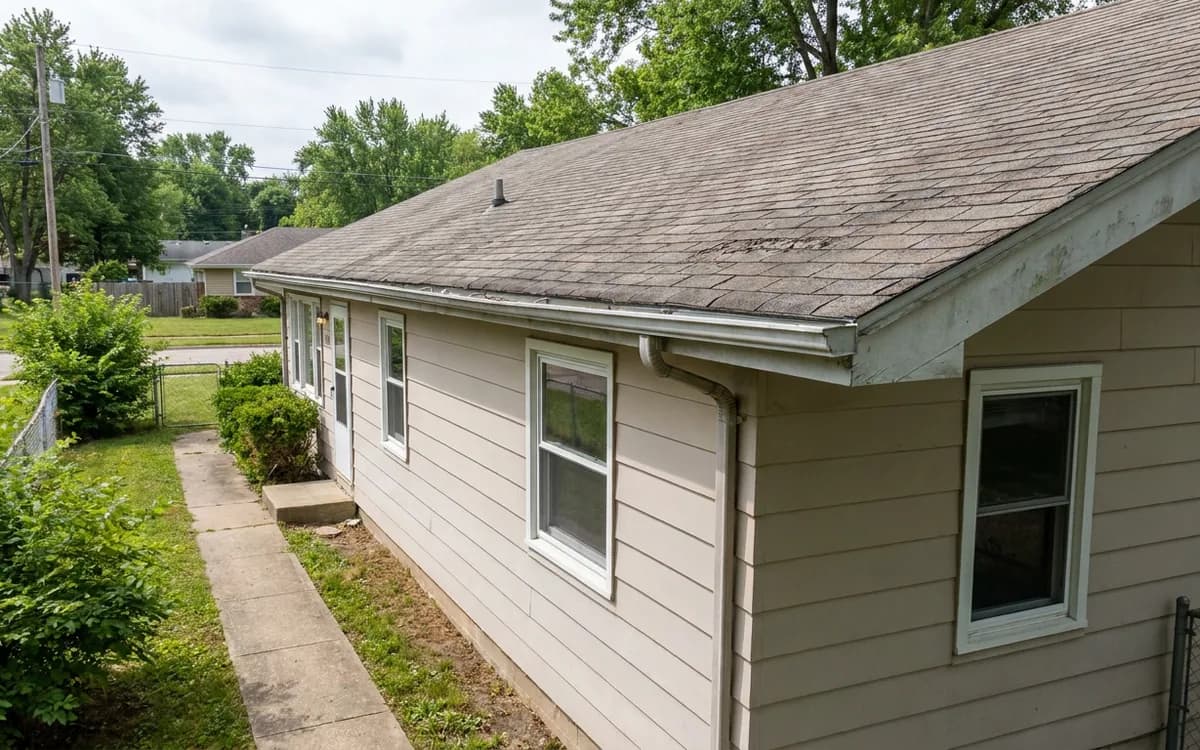 Single-family rental roof and gutters viewed from a clear side walkway